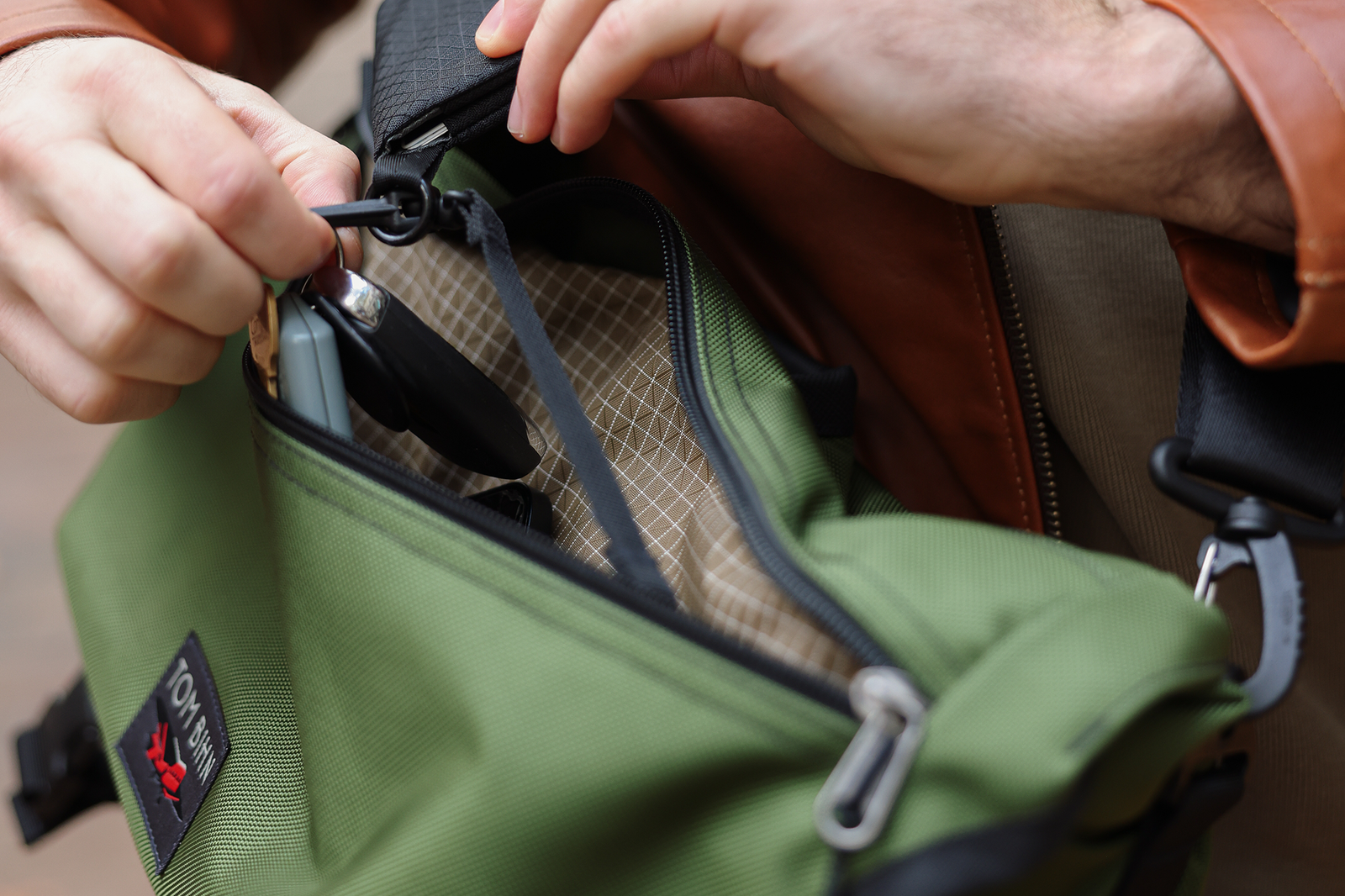 visible lifestyle^^A person accessing the front pocket of a Marathon Messenger
