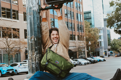 visible lifestyle^^A person hanging from a street pole wearing a Marathon Messenger