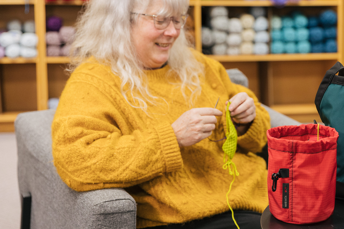 Person knitting out of a Small Yarn Stuff Sack