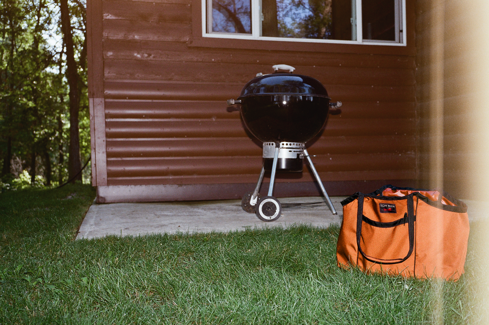 visible lifestyle^^A Truck in the grass in front of a cabin, the photo has a analog film imperfection (some overexposure on the right side).