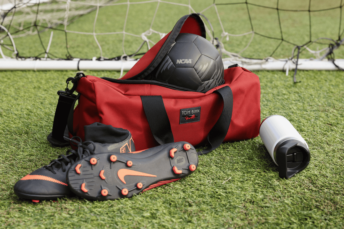 lifestyle  visible^^Small Yeoman filled with soccer gear, laying in the grass.