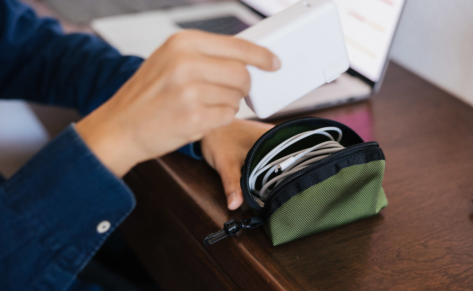 visible lifestyle^^A mini Q-Kit with a Lightning cable coiled inside it.