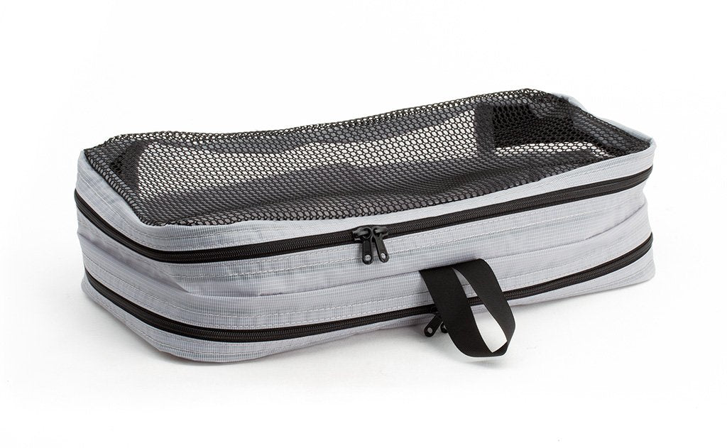 visible variant TB90601-NE^^An empty and zipped closed Northwest Sky (light grey) Aether Small Laundry Aeronaut 45 Packing Cube mesh side up.