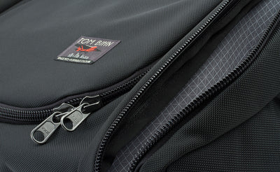 detail visible^^The label of the bag is offset to the right near the bottom of the main pocket's fabric lid. It features a red Farman Jaribu plane over a cityscape and the words "Portable Culture" embroidered near the bottom.