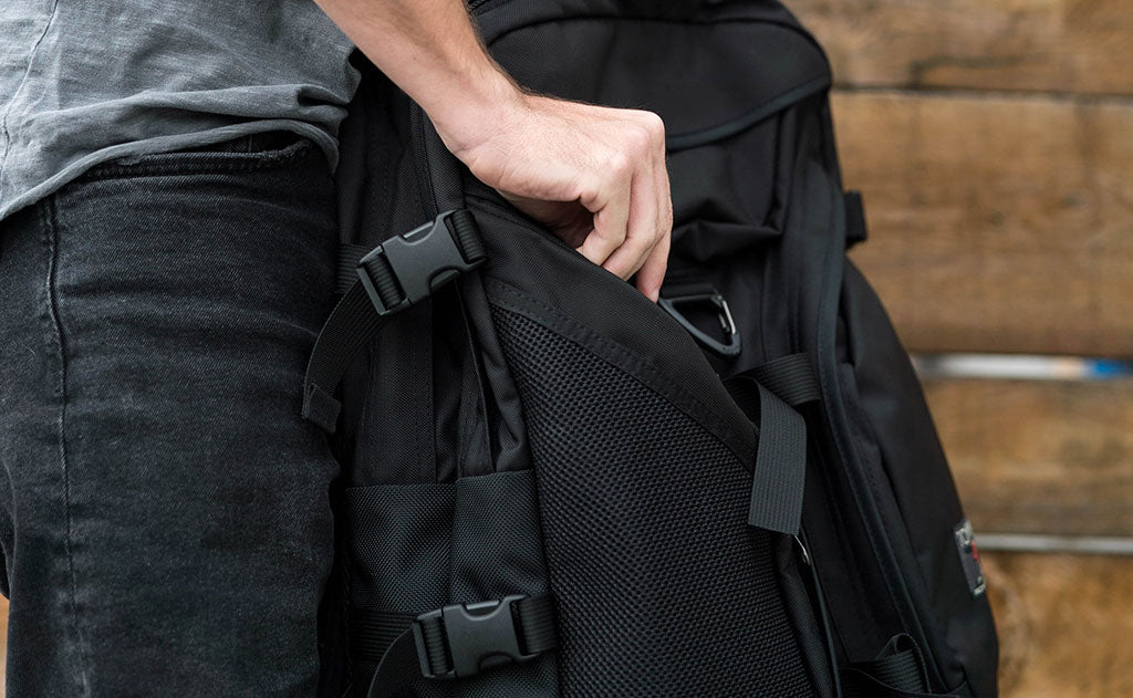 lifestyle visible^^A person accessing the front left zippered pocket in the Brain Bag.