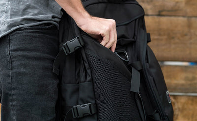 lifestyle visible^^A person accessing the front left zippered pocket in the Brain Bag.