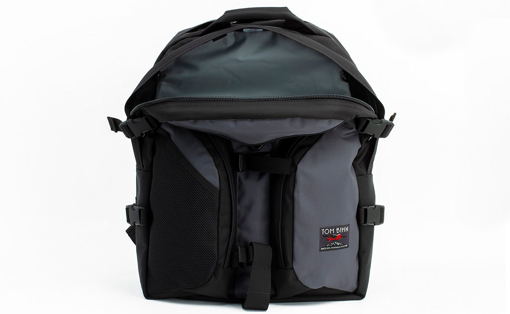 visible variant TB0104-GKLJ TB0114-GKLJ^^The Brain Bag in Nebulous Grey (dark grey) 525 Ballistic with the front main compartment zipper opened to reveal its Cloud (light grey) 210 Ballistic interior.