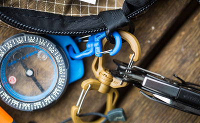 detail visible^^A Small Double Carabiner connecting a compass and a Medium Double Carabiner connecting a pocket knife to the same o-ring in a Handy Little Thing.