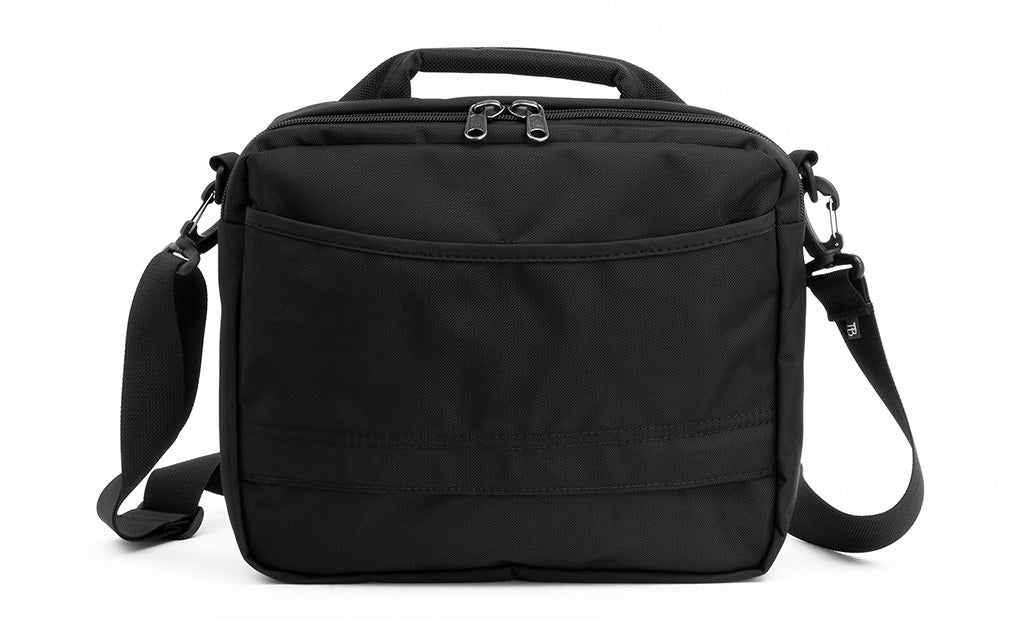 lifestyle visible^^Photo showing the back of the Co-Pilot with its open-top pocket and bottom zipper so it can fit over the handle of rolling luggage.