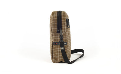 visible variant TB0416-CDNE TB0416-CDLE^^A side view of the Everyday Cubelet in Coyote Halcyon (brown with a white grid) showing the o-ring attachment point and included 5/8" strap.