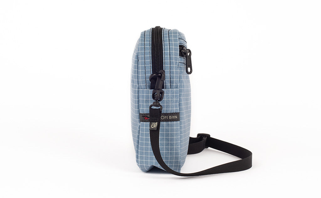 visible variant TB0416-7DNE TB0416-7DLE^^A side view of the Everyday Cubelet in Tidal Halcyon (faded blue with a white grid) showing the o-ring attachment point and included 5/8" strap.