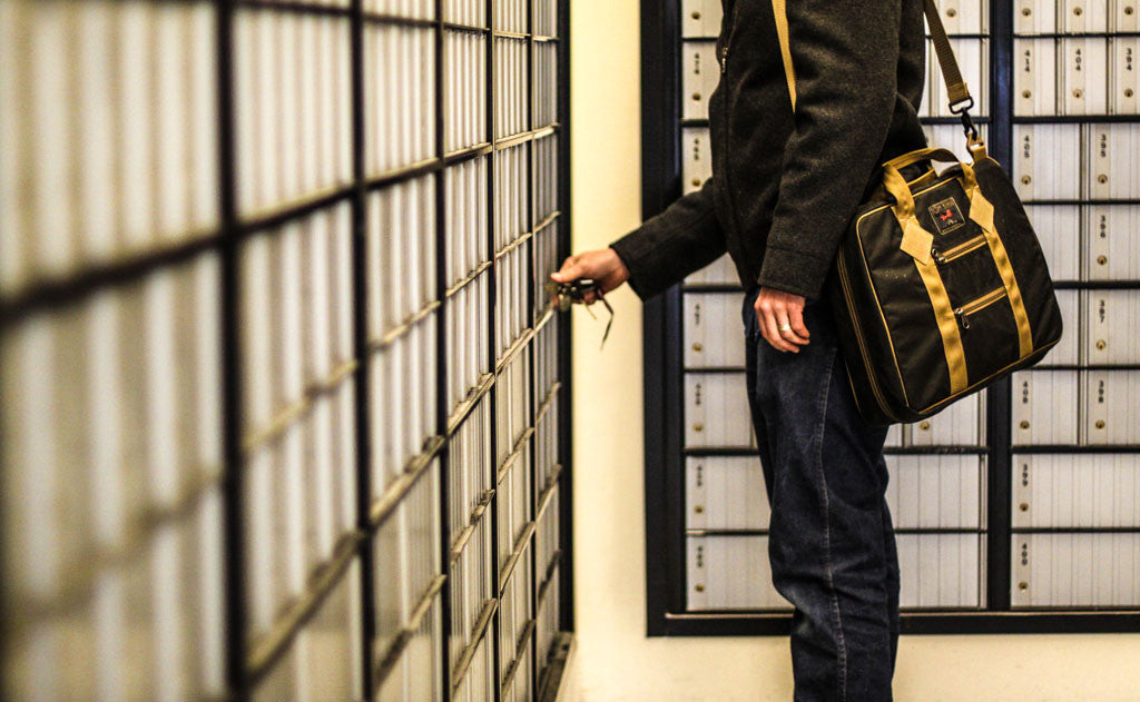 A person in profile wearing the Founder's Briefcase on one shoulder.