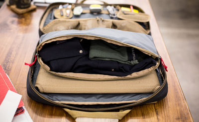 A Wedge Packing Cube attached to the Founder's Briefcase, open to reveal clothes inside.