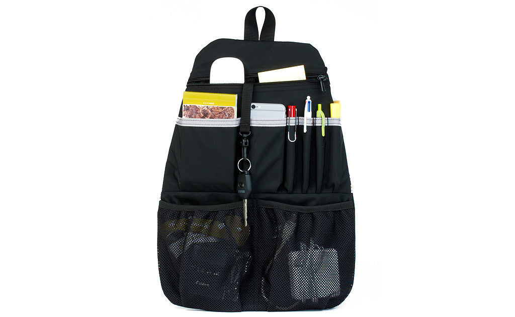 visible variant TB1843-BJ ^^ A Black Synapse 25 Freudian Slip holding pends, a small notepad, a wireless mouse, pens, cables, and charger.