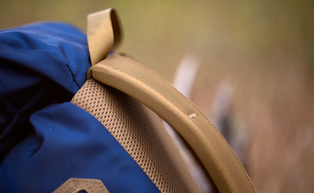 lifestyle visible^^A close shot of the seam attaching the nylon grab handle, backpack straps, and top pocket of the Guide's Pack.