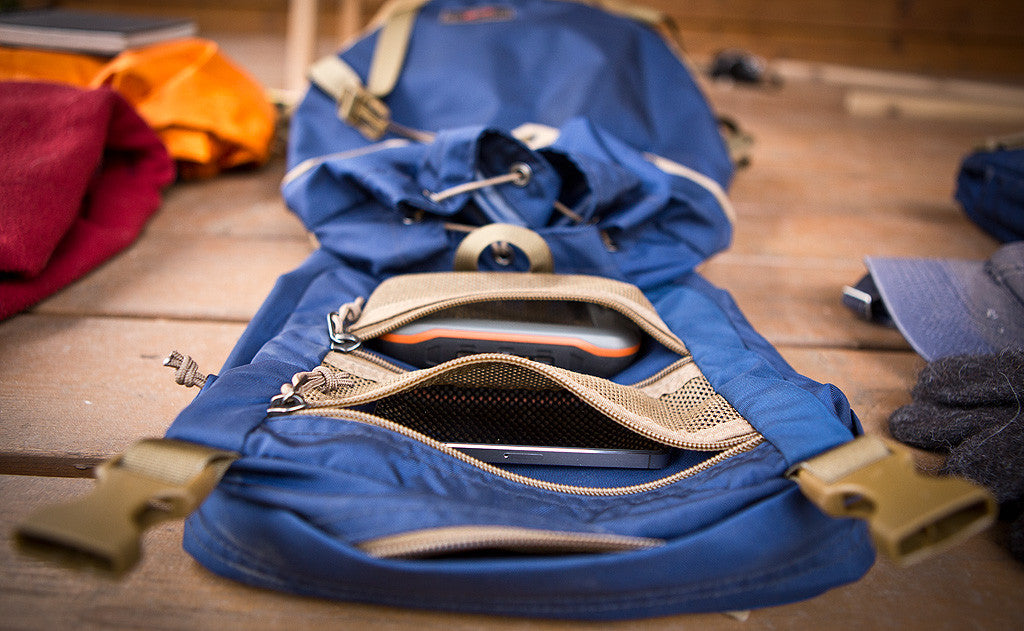 lifestyle visible^^The Guide's Pack's top flap with its mesh pockets opened to reveal a GPS in one and a cellphone in the other.