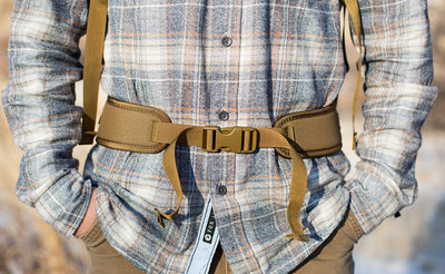 lifestyle visible^^A close shot of a person using the optional padded hip belt of the Guide's Edition Synapse 25.