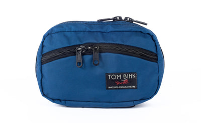 visible variant TB0418-IJ^^The front of a Handy Little Thing #1 in Island (blue) 210 Ballistic showing the front zipper with two slider and logo at the bottom-right corner.