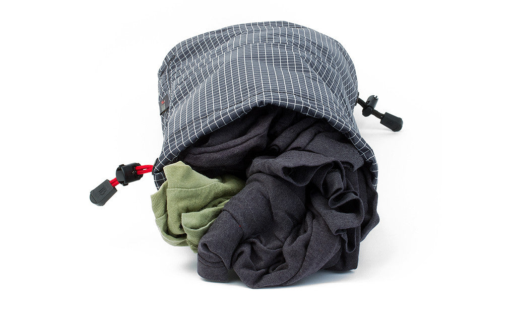 detail visible^^A Travel Laundry Stuff Sack showing dirty clothes in one side.