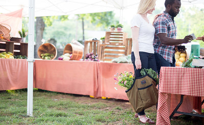 lifestyle visible^^A person carrying a full Moveable Feast at a farmer's market.