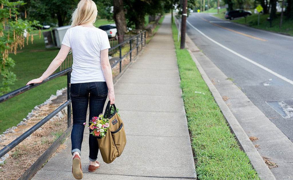 lifestyle visible^^A person carrying a full Moveable Feast down a sidewalk.
