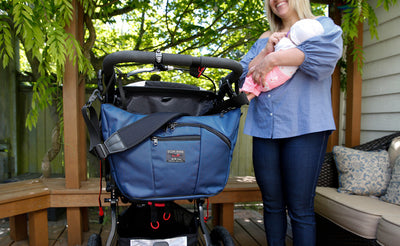 lifestyle visible^^Parental Unit hung to a stroller using the Stroller/Wheelchair Strap.