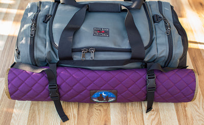 lifestyle visible^^The Road Buddy Lash Straps holding a rolled Skookum Dog Camp Mat on a Road Buddy Duffel 60.
