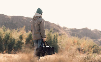 lifestyle visible^^A person carrying the Road Buddy Duffel via the padded carry handle.