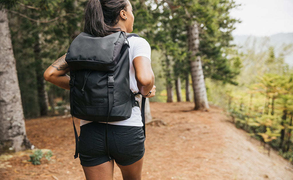 visible lifestyle^^Woman wearing the Shadow Guide 33 on a hike; full view of the bag and label.