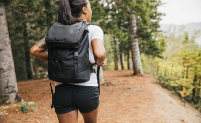 visible lifestyle^^Woman wearing the Shadow Guide 33 on a hike; full view of the bag and label.