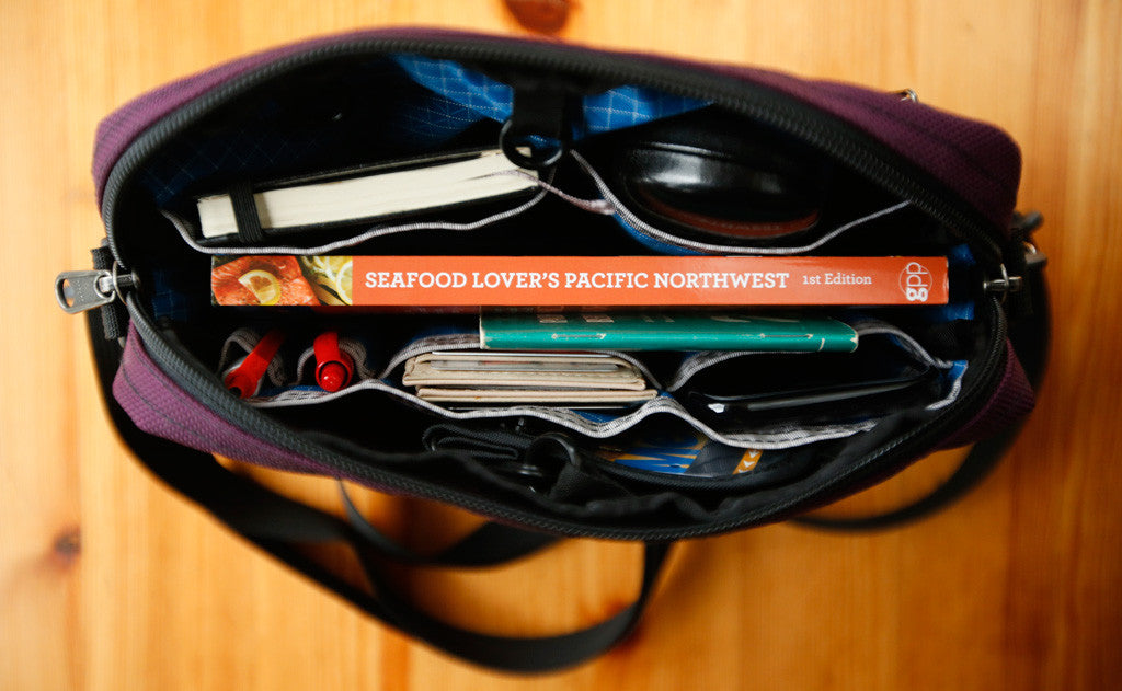 detail visible^^A full Side Kick with a couple books, a pocket notepad, pens,  a phone, stamps, and a wallet.