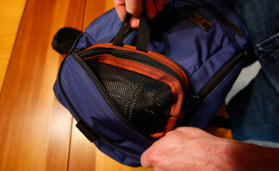 lifestyle visible^^A person inserting a Small Snake Charmer into the bottom pocket of a Synapse 19.