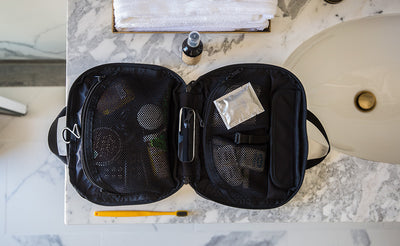 lifestyle visible^^The Deluxe Spiff Kit zipped open on a hotel restroom counter.