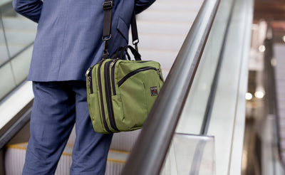 lifestyle visible^^A person on an escalator carrying The Stowaway via a shoulder strap.