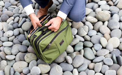 lifestyle visible^^A person accessing magazines from the rear main pocket of The Stowaway.