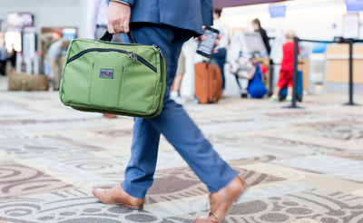 lifestyle visible^^A person carrying The Stowaway via the padded handles.