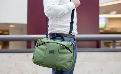 lifestyle visible^^A person on an escalator carrying The Stowaway via a shoulder strap.