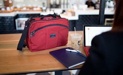 lifestyle visible^^A person at a coffee shop using their tablet with The Stowaway on the tabletop beside them.
