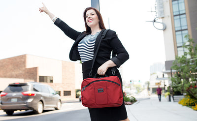 lifestyle visible^^A person hailing a cab while carrying The Stowaway via a shoulder strap.