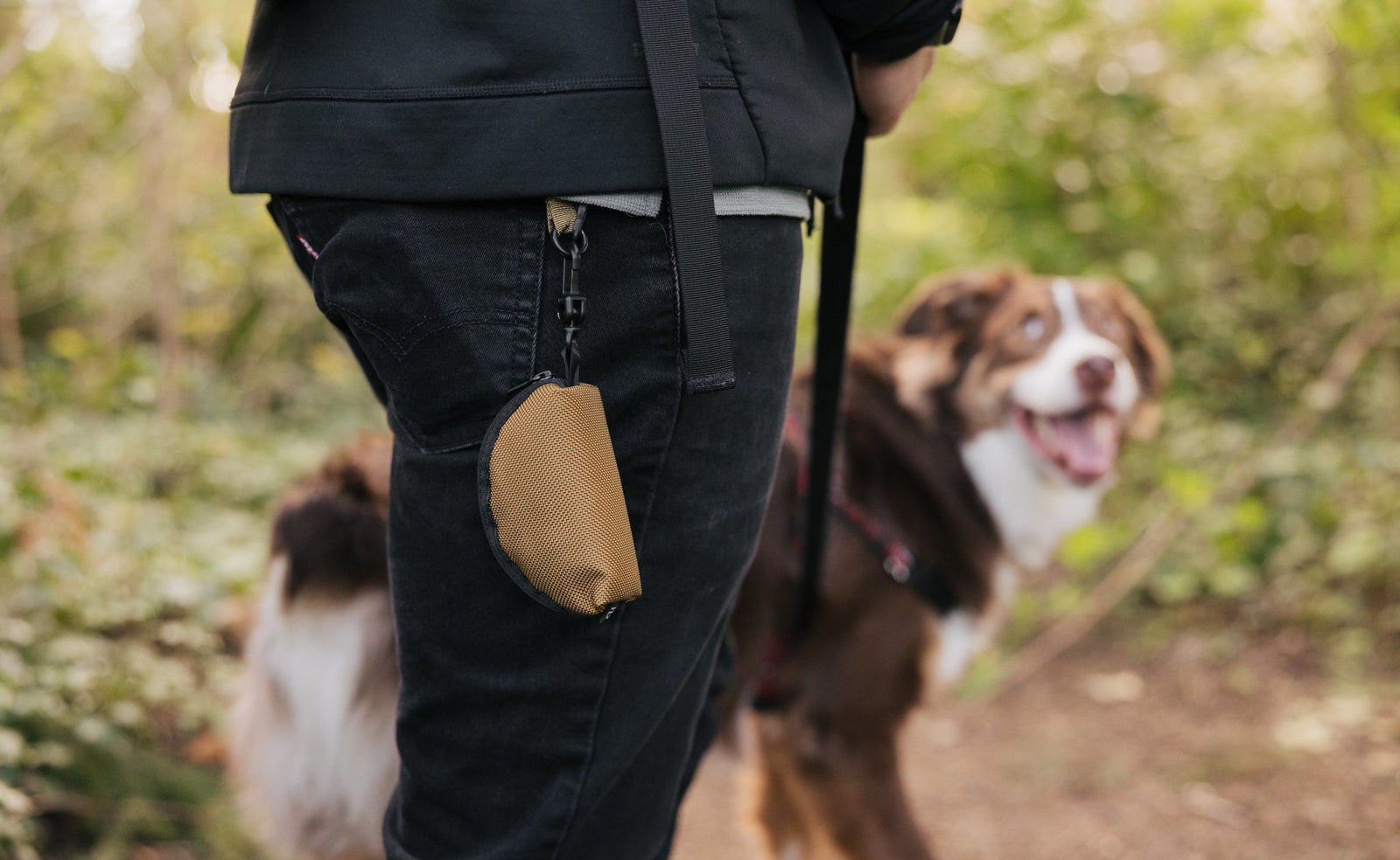 visible lifestyle^^A Mini Coyote Q-Kit hanging from a person's belt loop by a Key Strap with a dog looking at the person. 
