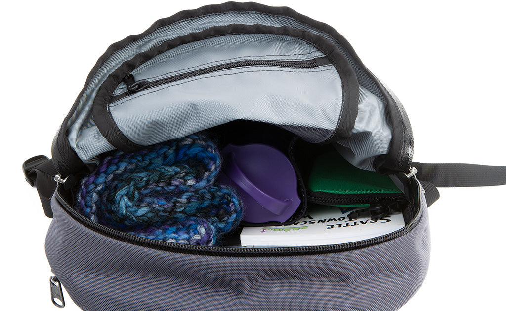 detail visible^^A water bottle, organizer pouch, scarf, and book in the main pocket.