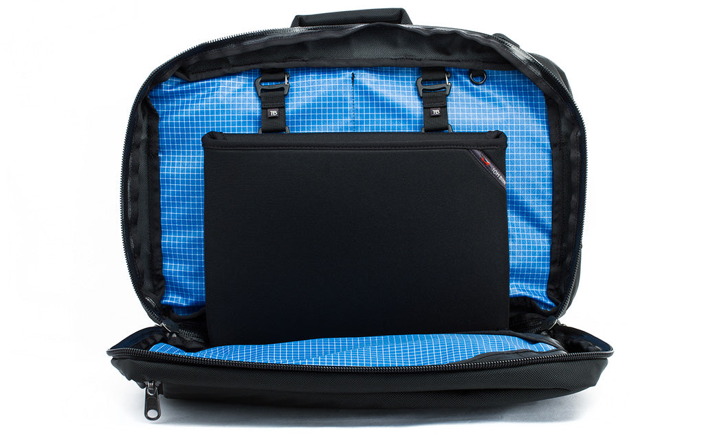 detail visible^^The rear main pocket of a Black 525 Ballistic exterior Western Flyer opened to reveal an Island (blue) 200 Halcyon interior with a Cache connected to the nylon loops sewn into the interior seam.