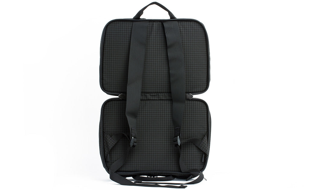 visible variant TB0975-BHND^^A side-on shot of A shot of the face of The Stowaway in Black (black with grey grid) 400 Halcyon with the main compartment open to access the backpack straps.
