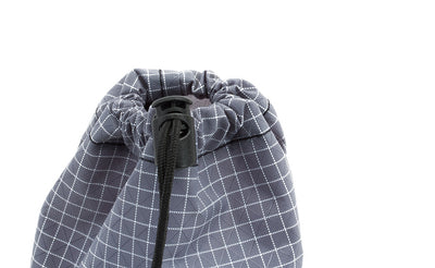detail visible^^A close shot of a Size 1 Northwest Sky (light grey with white grid) 200 Halcyon Travel Stuff Sack with it's drawstring cinched shut and held in place using the thumb-operated locking piece.
