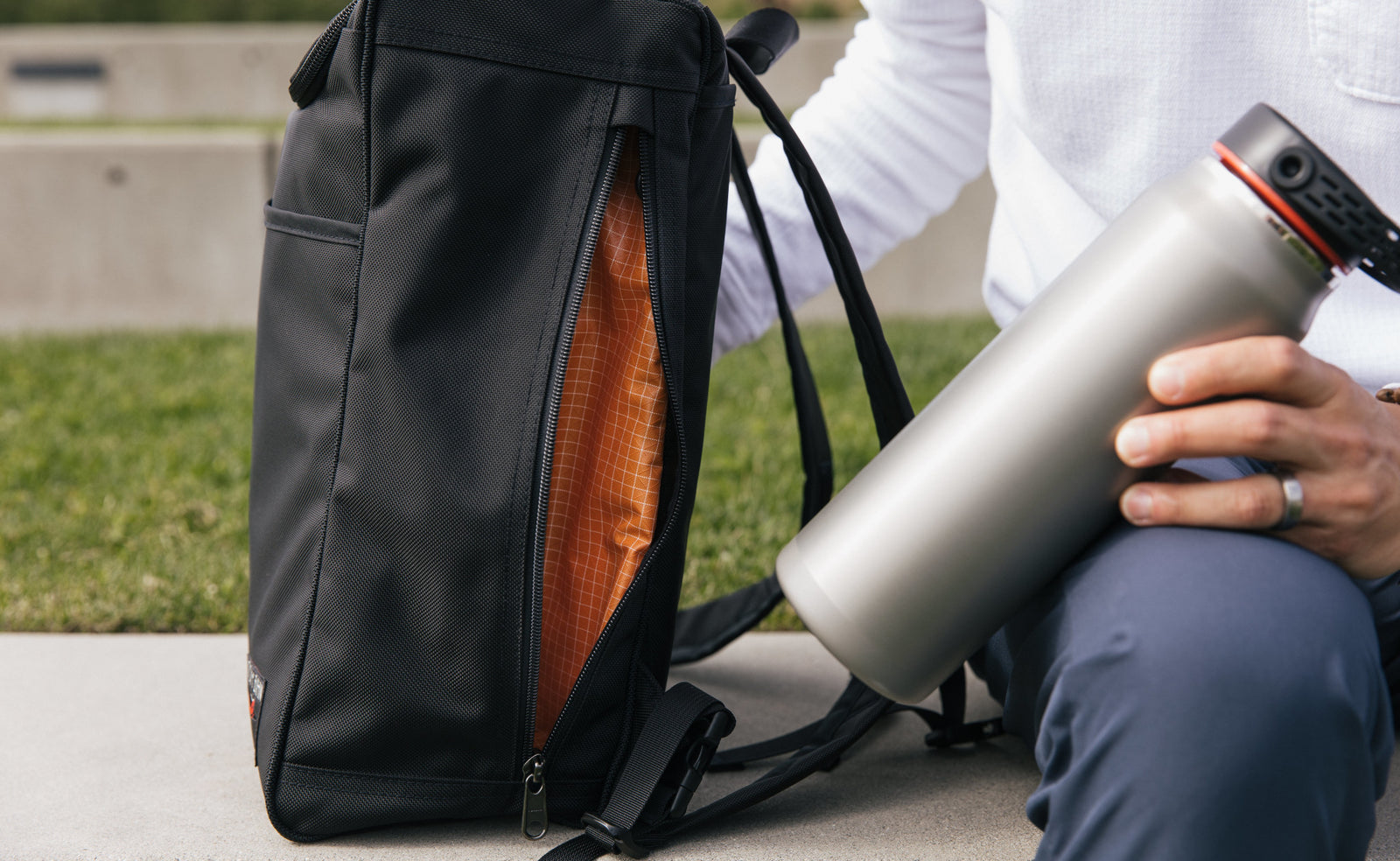lifestyle visible^^A waterbottle next to the large exterior pocket of the Cambiata.