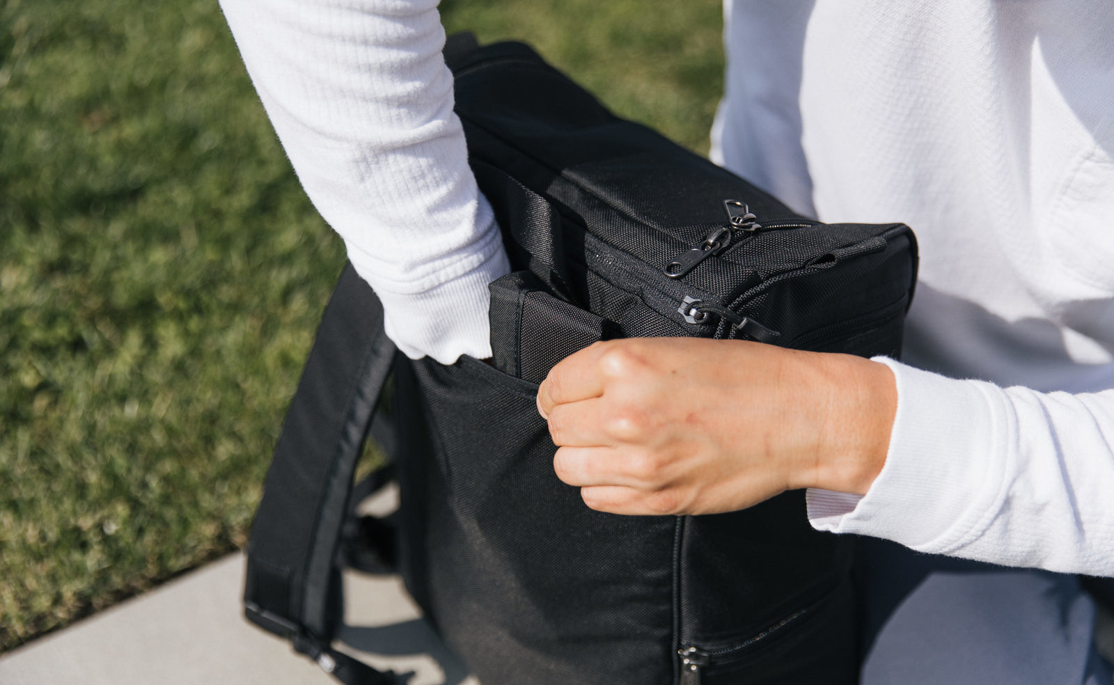 lifestyle visible^^Person tucking away the backpack straps.
