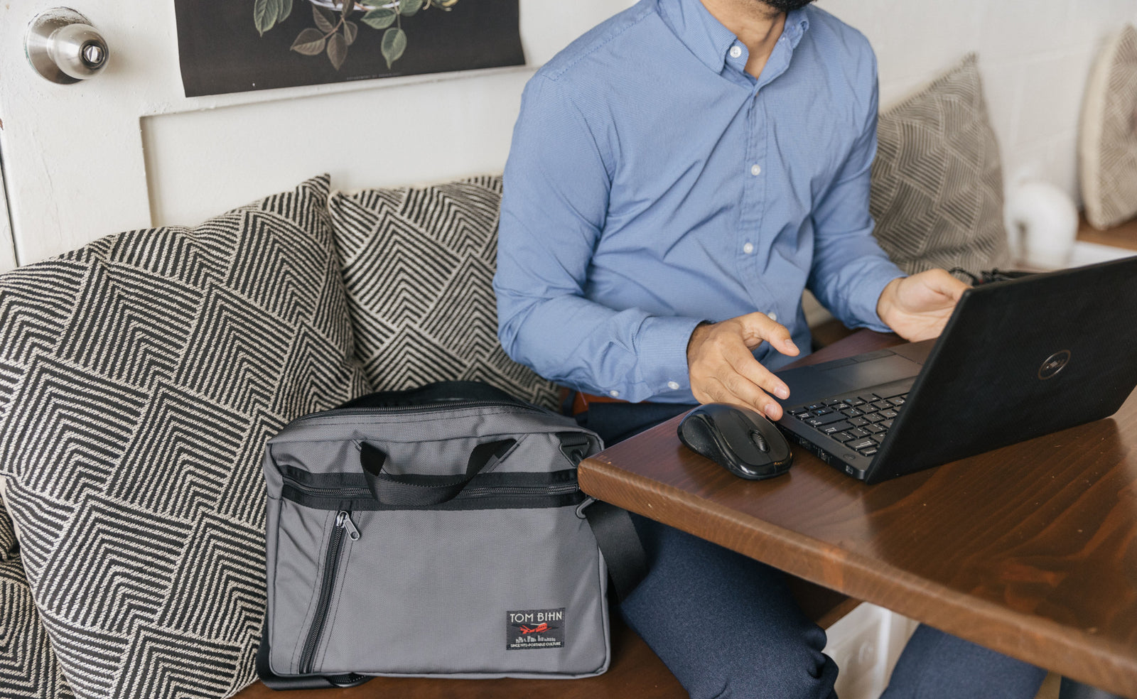 lifestyle visible^^A person sitting at a table with laptop open and a Nebulous Grey Daylight Briefcase sitting next to them.