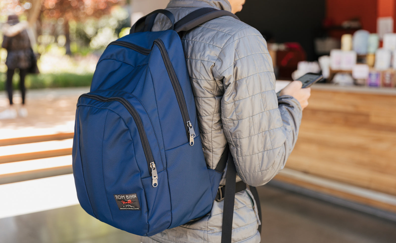 lifestyle visible^^A person in line at a cafe wearing a Deep Blue Paramour. 