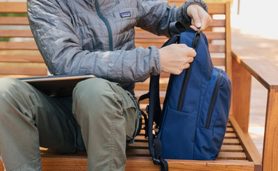 lifestyle visible^^A person sitting on a bench unzipping a Deep Blue Paramour.