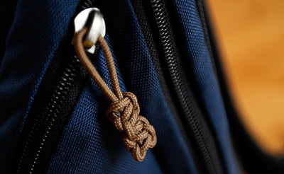visible variant TB0512C-CA^^Cord Zipper Pulls knotted and attached to a bag's zipper sliders directly